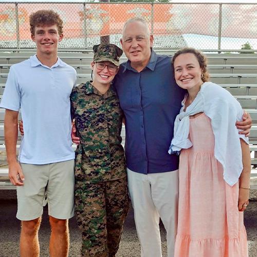 Image of Jackie Piddock in her military uniform with her family.